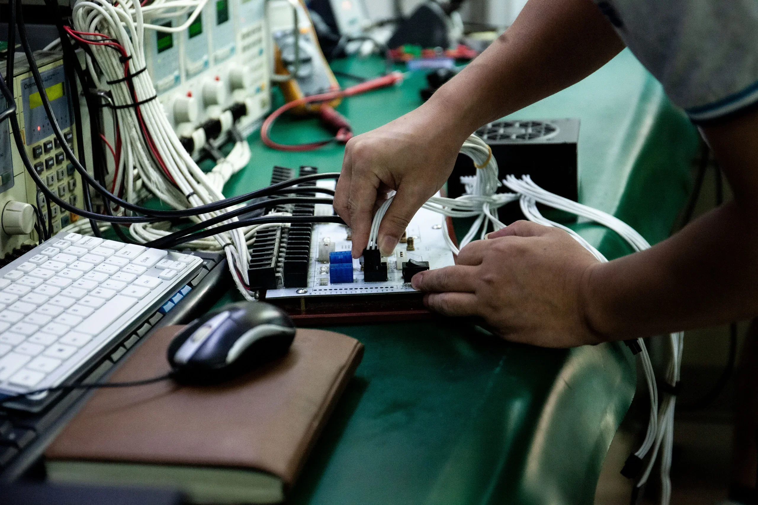 1STPLAYER technician conducting individual PSU test — each NGDP power supply unit is tested before shipping